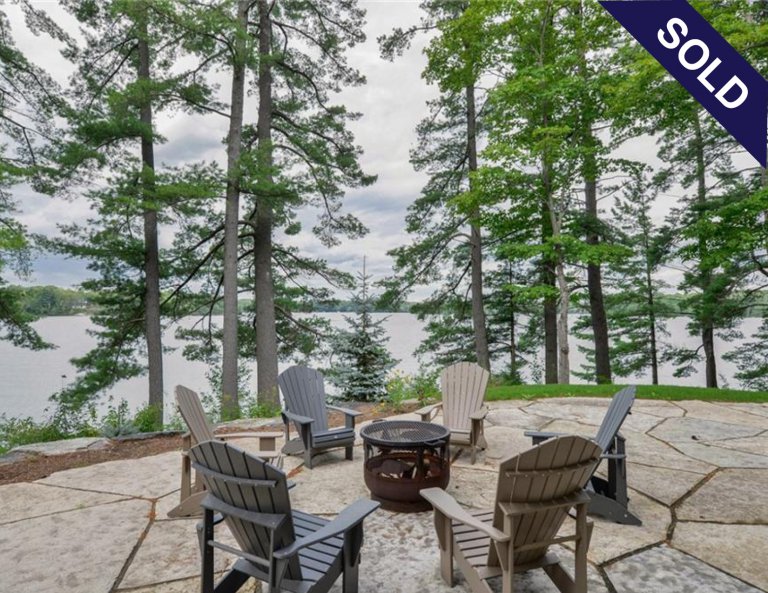 Muskoka waterfront cottage exterior with trees.